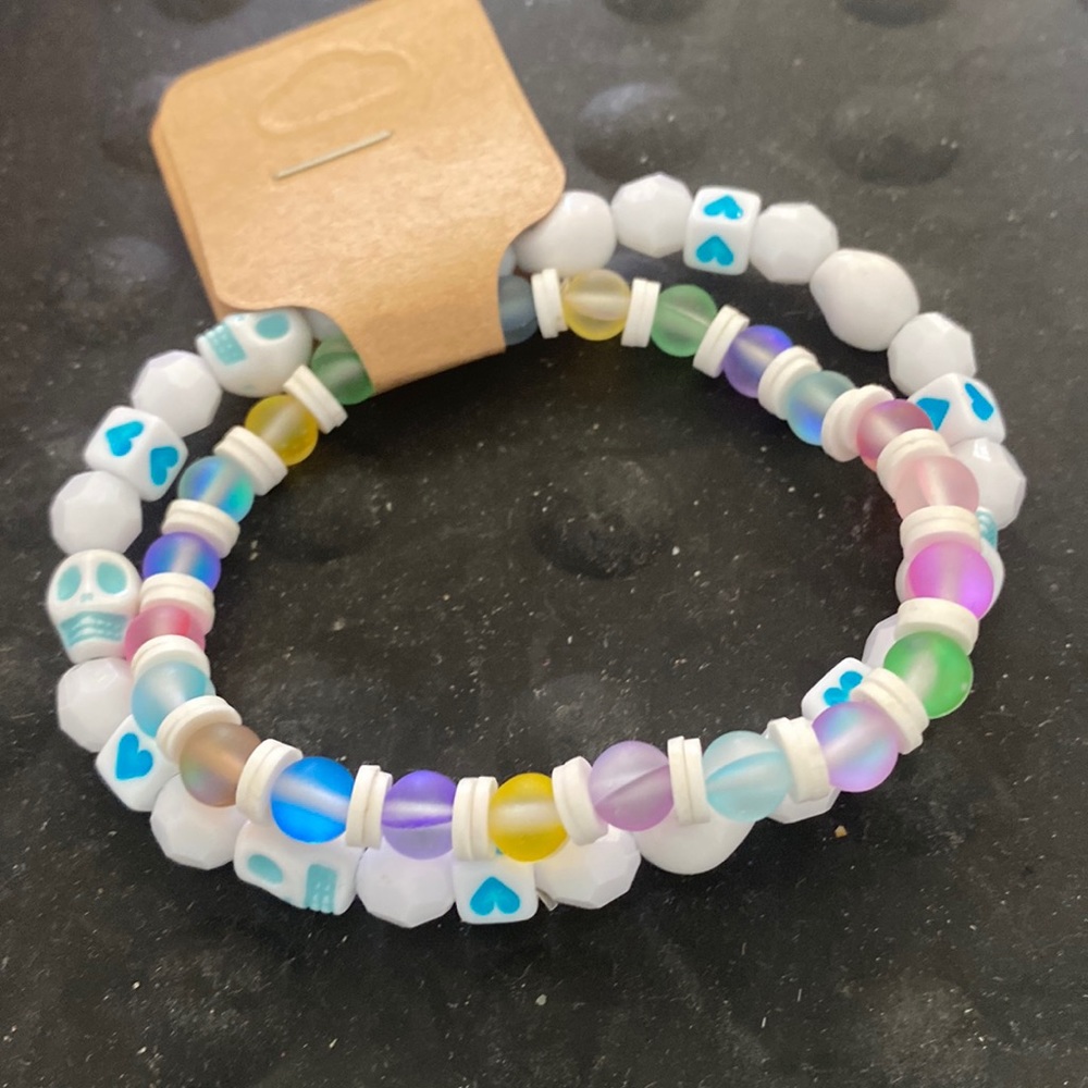 2bracelets one w/ skulls and hearts, the other one with illuminating glass beads